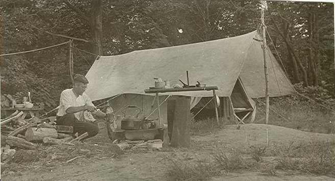 Man cooking beside a tent