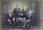 Four unidentified men pose for a studio portrait.  Photo is mounted on 8" x 10" heavy board.